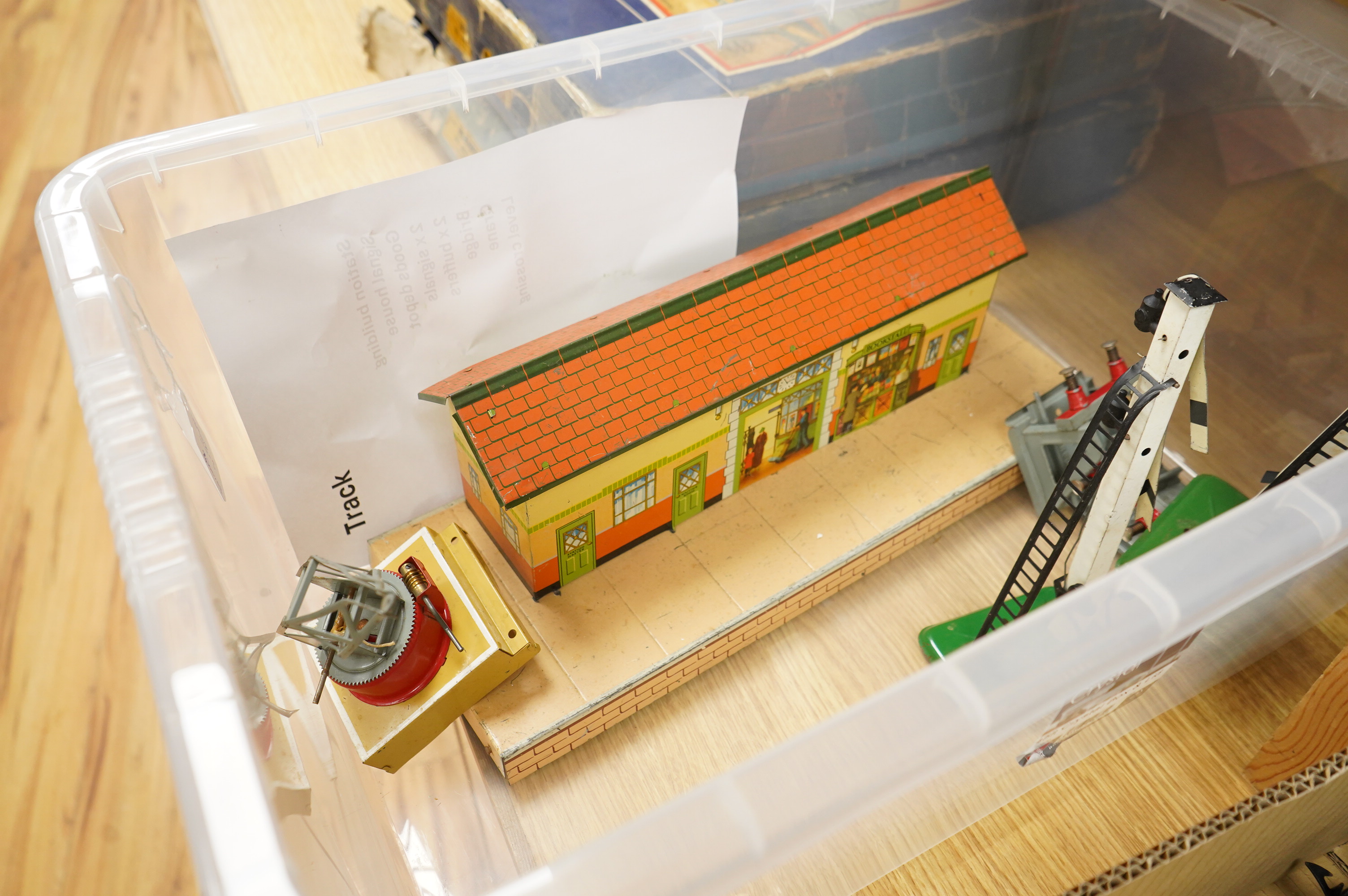 A collection of 0 gauge Hornby tinplate clockwork railway, including four BR locomotives, 17 freight wagons and four wheel coaches, together with a station building, signal cabin, and Goods depot (missing base), plus a f